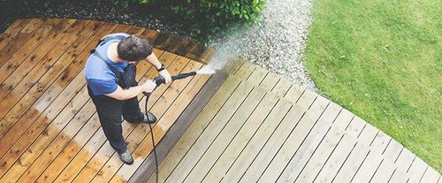 Man Power Washing Wood Deck